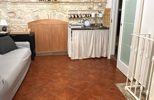 Molfetta House | Grotta Paradiso, a two-story stone cottage with a warm and cozy charm.